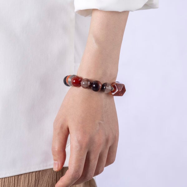 Energy boosting bracelet on wrist, worn casually with neutral white top.