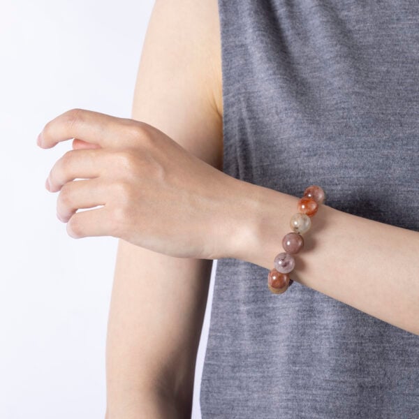 Red rutile quartz bracelet worn close to skin in soft lighting