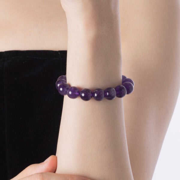 Close-up of amethyst bracelet on bare wrist with soft lighting